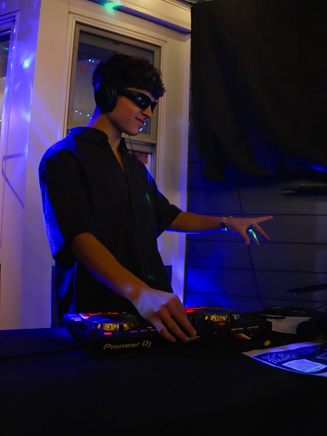 DJ Frieds smiling behind the decks with headphones on