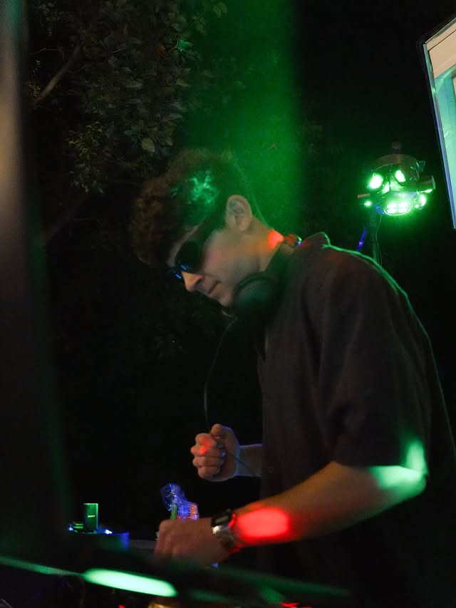 DJ Frieds working the controller under green laser lighting